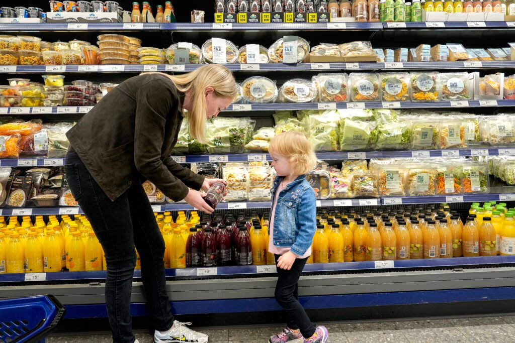 Mor handler juice med sin datter i en dagligvarerbutik