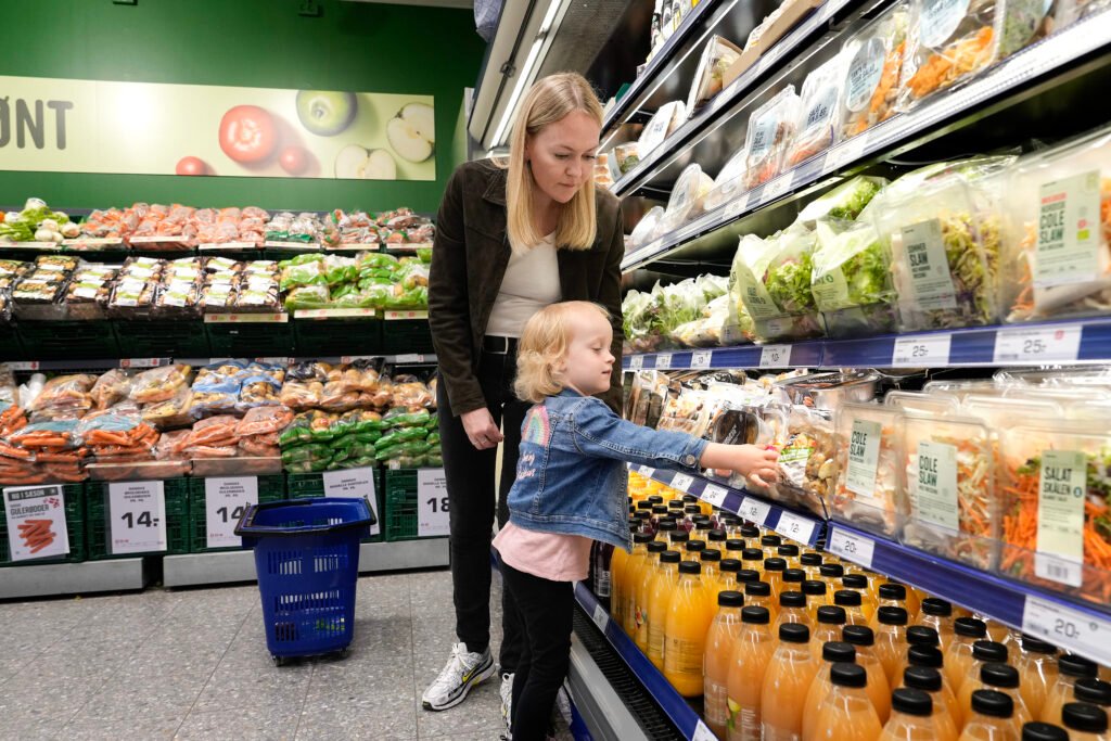 Mor og barne handler dagligvarer hos en købmand